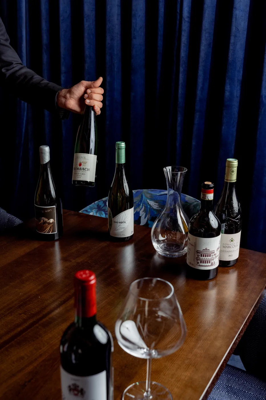 Bottles of wine and a glass decanter on a table at Layla
